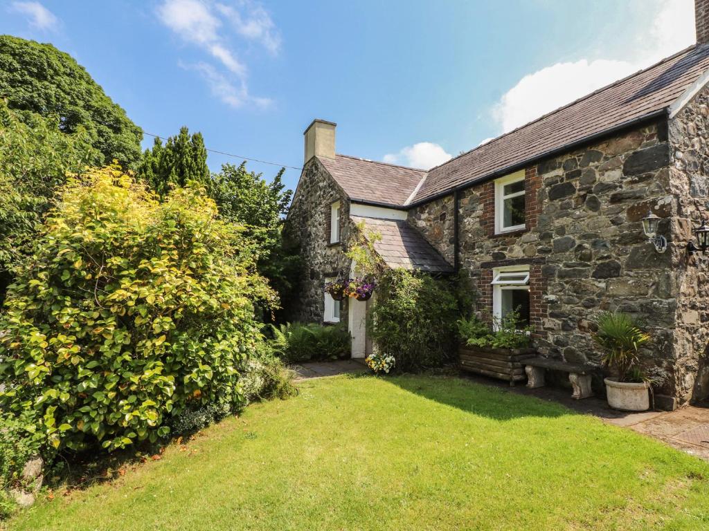 an exterior view of a stone house with a yard at Plas Mawr in Caernarfon