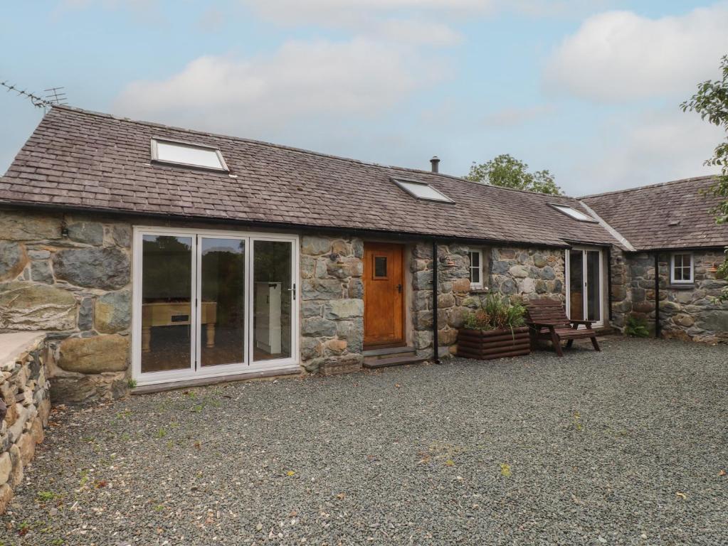 an old stone cottage with a large sliding glass door at Beudy'r Wennol in Caernarfon