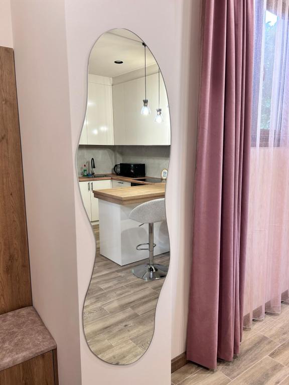 a mirror in a kitchen with a table and a stool at Your Cozy Home 2BR Local Vibe 25 Mins to Center in Yerevan
