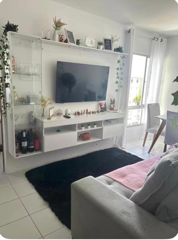 a living room with a white entertainment center with a tv at Apto no Janga in Paulista