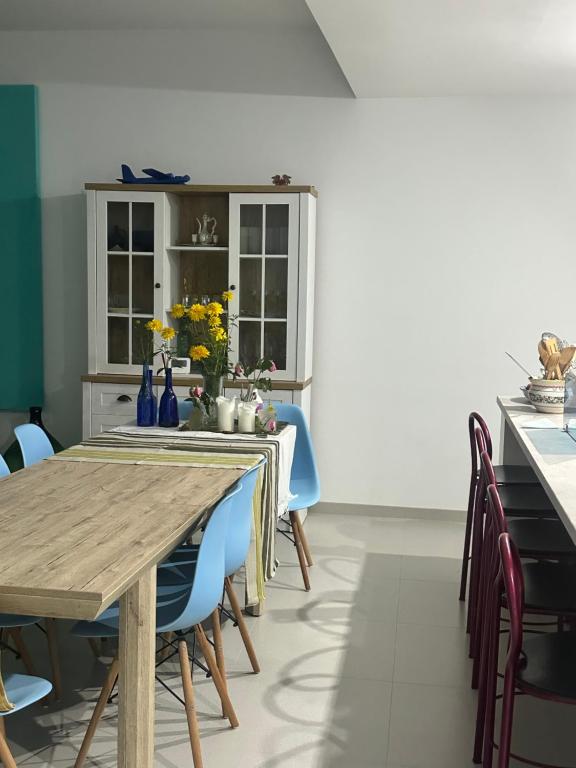 a dining room with a wooden table and blue chairs at Casa verde in Tuzla