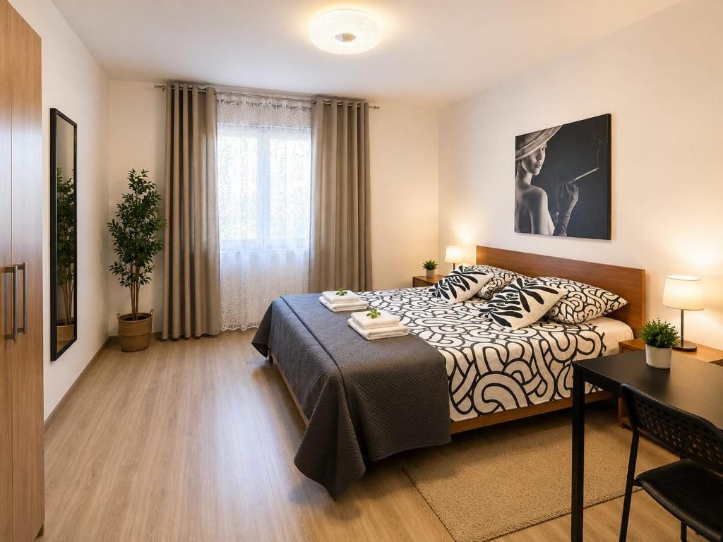 a bedroom with a bed and a desk and a table at Appartamento Orchidea in Monfalcone