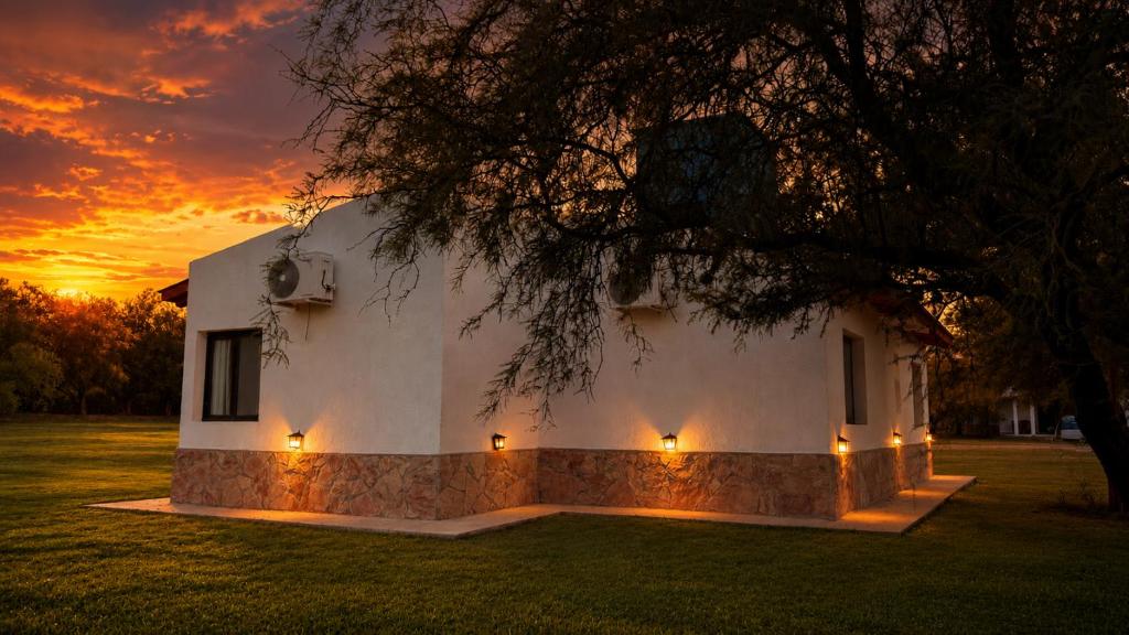 a house with lights in front of a sunset at Complejo Sol y Sombra in San Javier