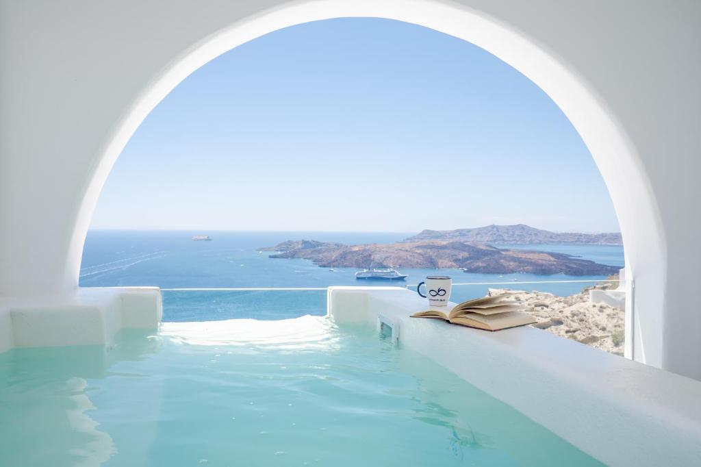 a view of the ocean from a swimming pool at Apeiron Blue Santorini by Apeiron Hotels in Fira