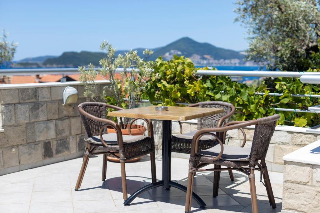 a table and chairs on a patio with a view at BMV TRIPLE ROOM WITH BALCONY in Sveti Stefan