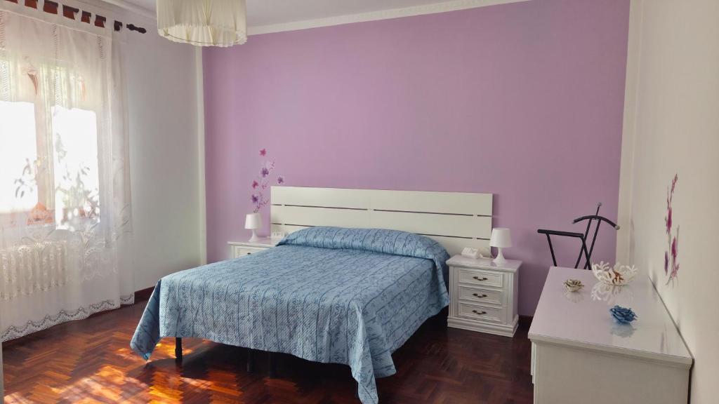 a bedroom with a bed with a blue comforter at Casa Kendra in Montegrotto Terme