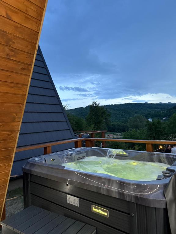 a hot tub on the deck of a house at A-Frame The Wolf Transfăgărășan in Căpăţîneni-Ungureni