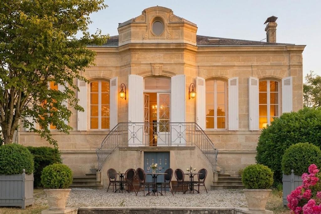 a mansion with a table and chairs in front of it at Château Papounan in Saint-Estèphe