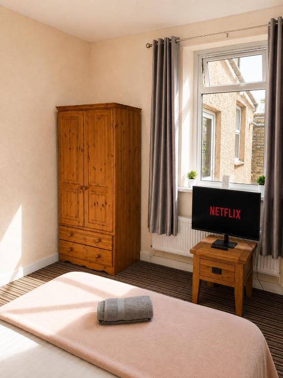 a bedroom with a bed and a tv and a window at 52 - room 2 - smart TV in Swansea