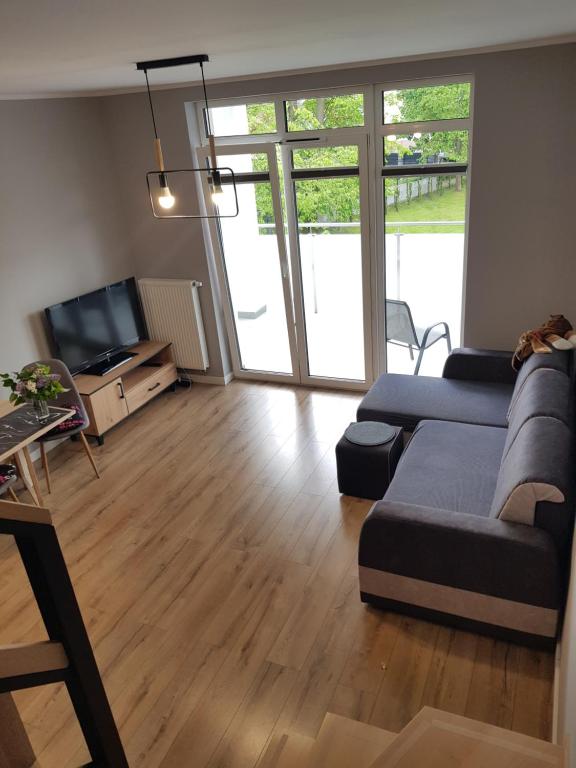 a living room with a couch and a tv at MazuryTime in Mrągowo