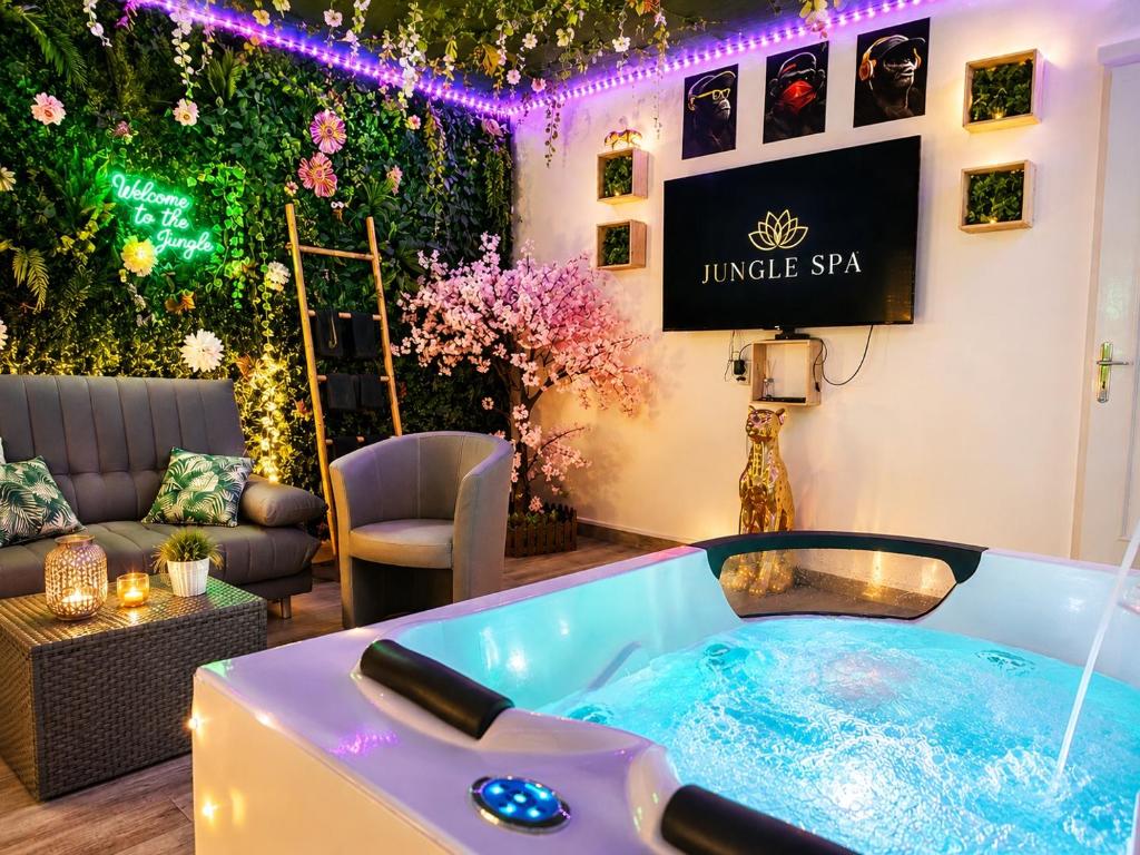 a jacuzzi tub in a living room with flowers at The Jungle SPA Strasbourg in Schiltigheim