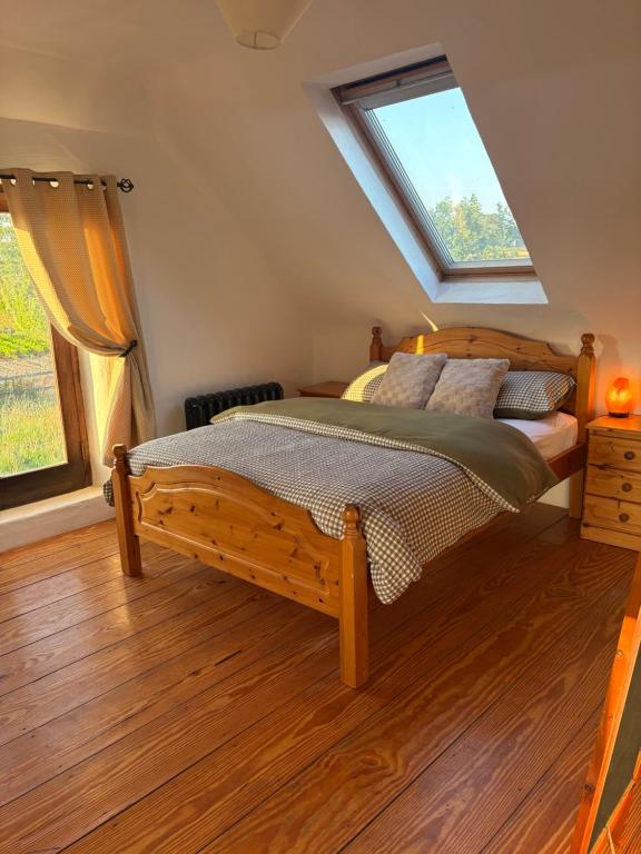 a bedroom with a wooden bed and a window at THE FARMHOUSE Room 2 in Balcunnin
