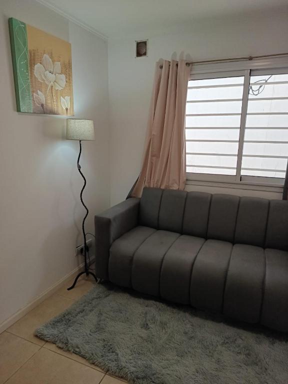 a living room with a couch and a window at Mi Refugio Venado in Venado Tuerto