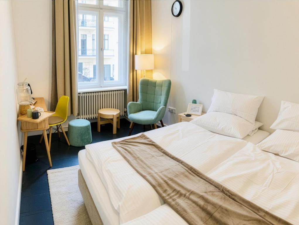 a hotel room with a bed and a chair at Serviced Room im Herzen Berlin‘s in Berlin