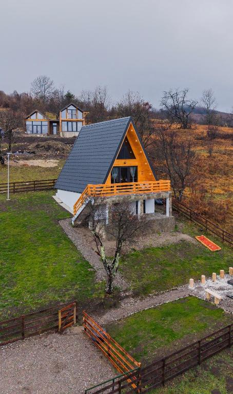 a house with a gambrel roof on top of a field at Art A Cabin in Teşila