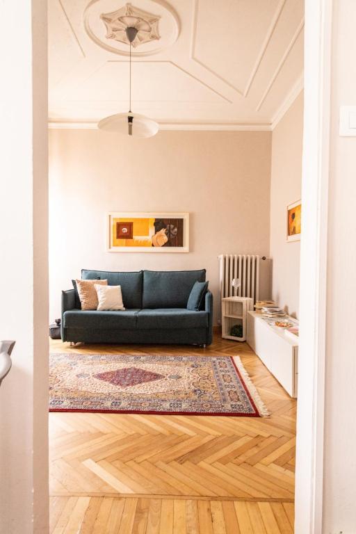 a living room with a blue couch and a rug at Savian Apartment in Savigliano