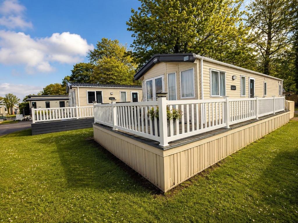 a mobile home with a white fence on a yard at Forest & Beach Escape in Sway