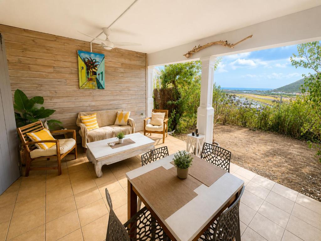 a patio with a couch and a table and chairs at Between Caribean Seas in Cul de Sac