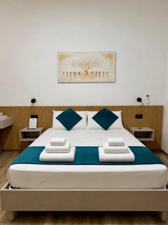 ein Schlafzimmer mit einem großen Bett und blauen Kissen in der Unterkunft CHD Rooms in Ancona