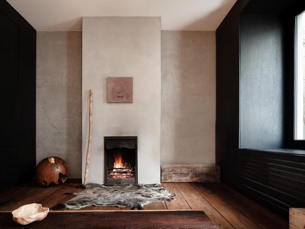 a living room with a fireplace and a wooden floor at Wabi Guesthouse in Ghent