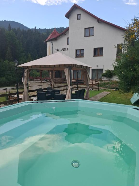 a swimming pool in front of a house at Vila Apuseni in Arieşeni