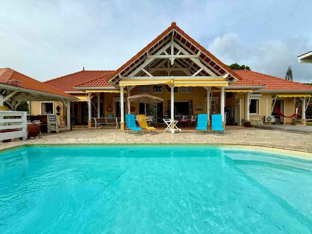 a house with a large swimming pool in front of it at VILLA PASKEDRA in Case-Pilote