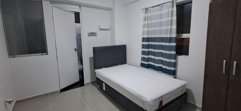 a small bedroom with a bed in a room at Casa La Torre in Lurín