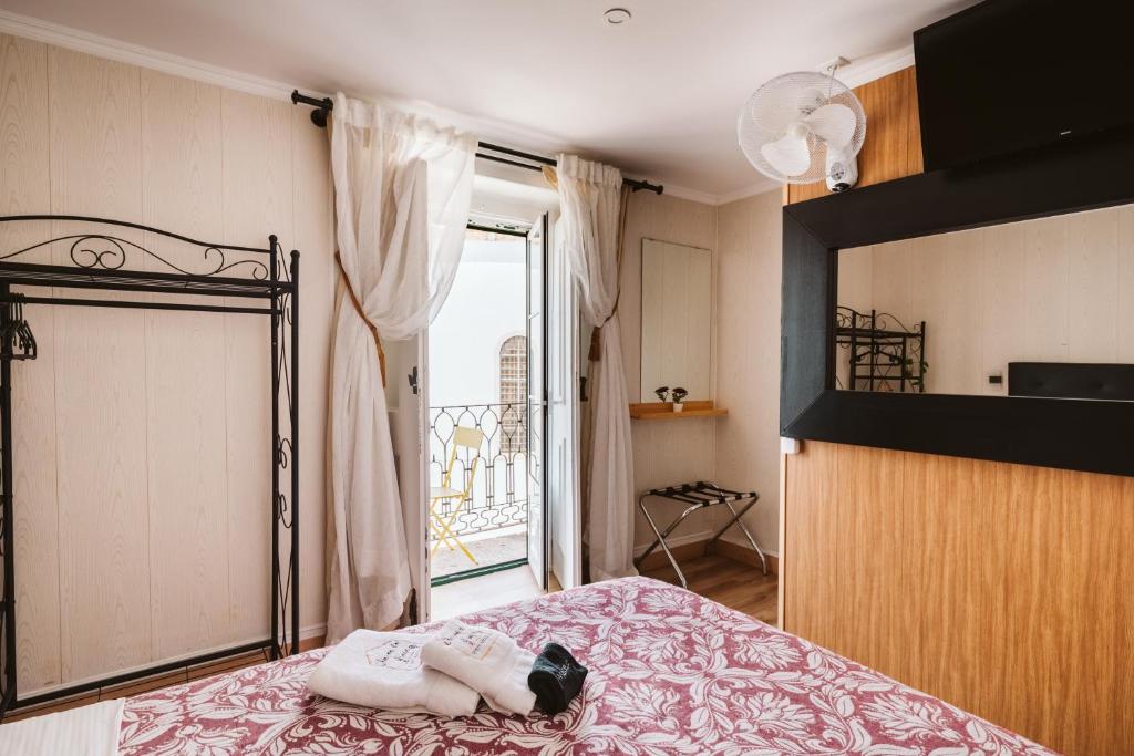 a bedroom with a bed and a large window at Graça Guest House in Lisbon