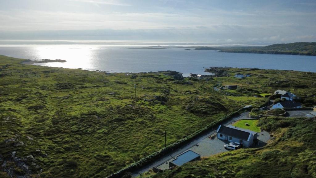 an aerial view of a house on a hill next to the water at Mary’s Seaview Clifden in Errislannan
