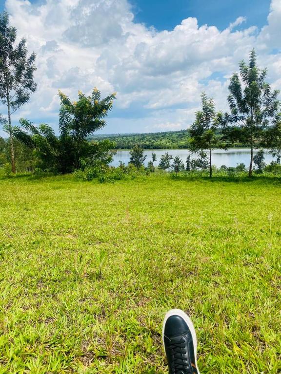 a persons shoe sitting in the grass near a lake at Umunota Escape in Bugesera
