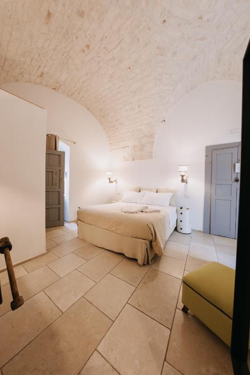 a bedroom with a bed and a tiled floor at Nobile Dimora di Puglia in Ostuni