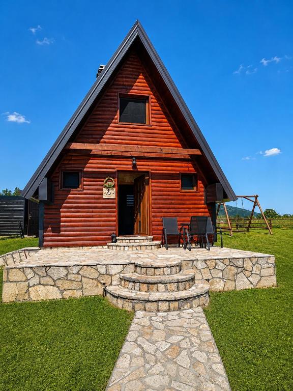 a log cabin with a porch and a table and chairs at Guest House Zabljak in Žabljak