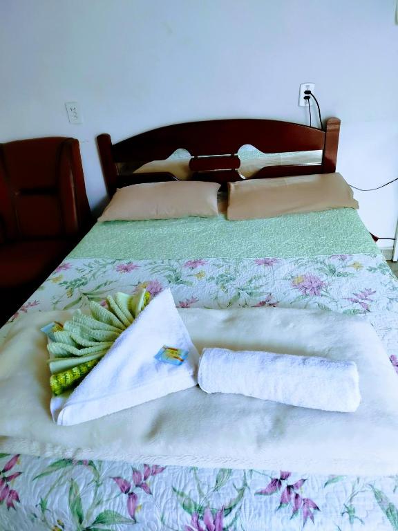 a bed with two towels and grapes on it at Minha casa pousada in Botucatu