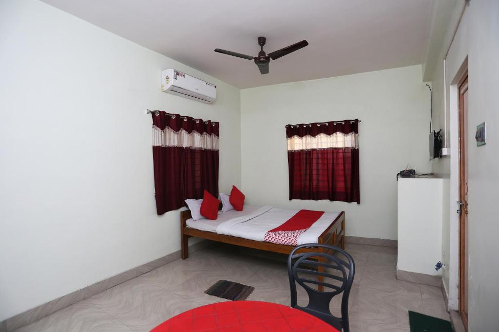 a small room with a bed and a chair in it at Hotel O Nandi Inn in Durgāpur