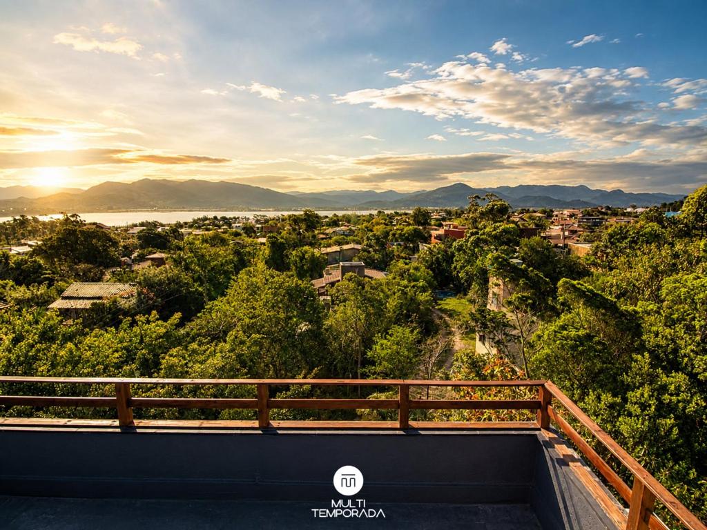 a view of a city from a balcony with the sun setting at Lugar ao Sol - Flats c/ Cozinha no Rosa in Praia do Rosa