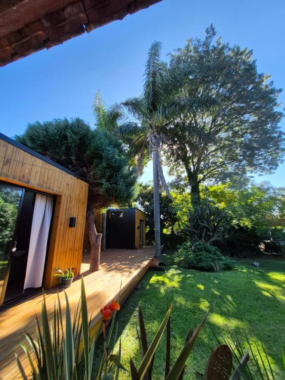 a backyard with a wooden deck and a palm tree at Bio Espacio in Belén de Escobar