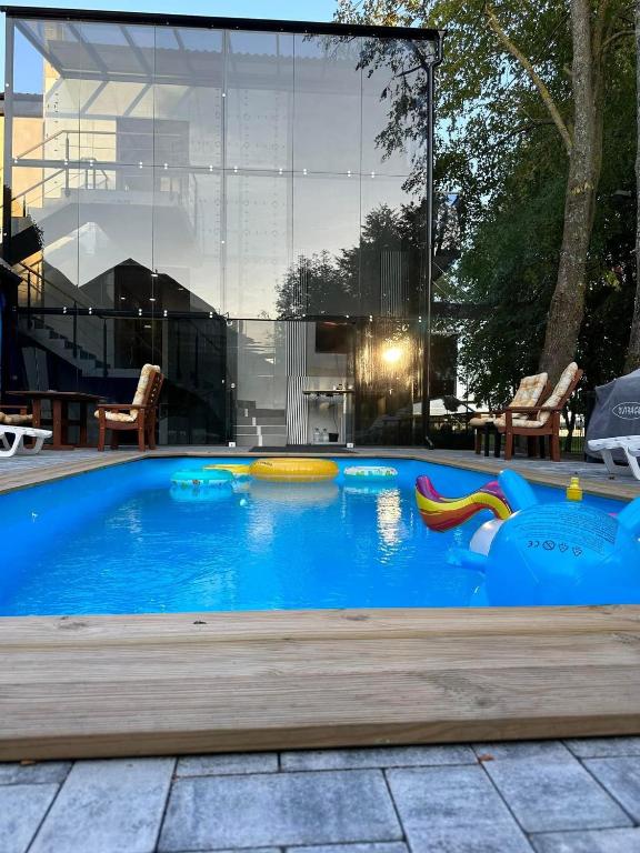 a swimming pool with a slide in front of a house at Vila LT11 centre su baseinu in Palanga