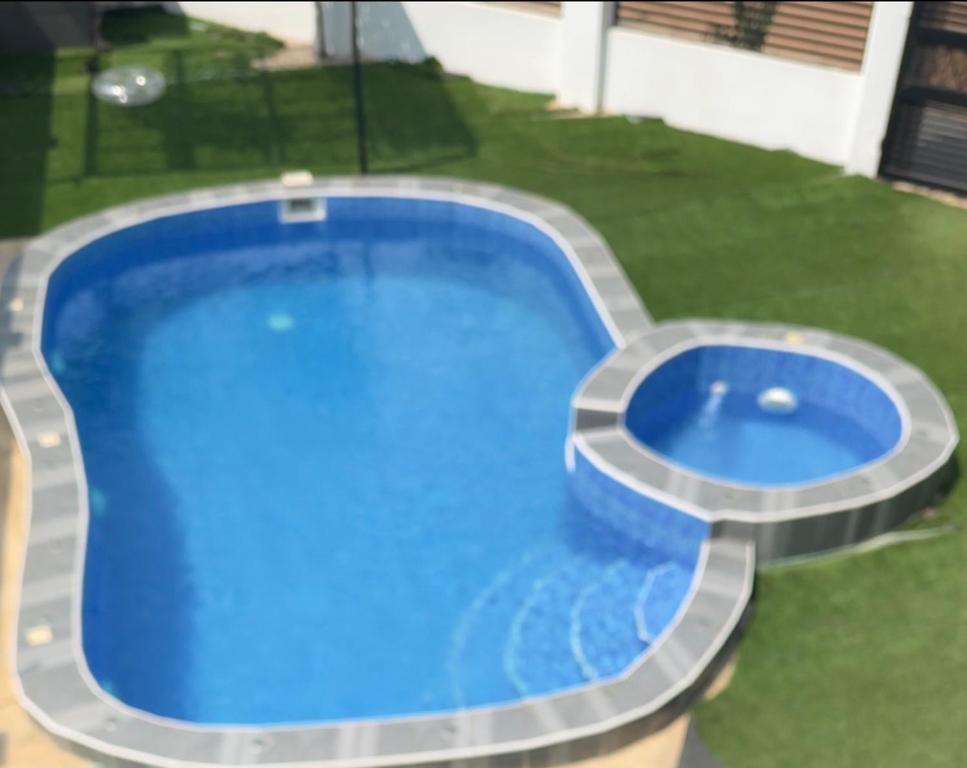 Draufsicht auf einen blauen Swimmingpool mit Rasen in der Unterkunft Cross Suites in Tema