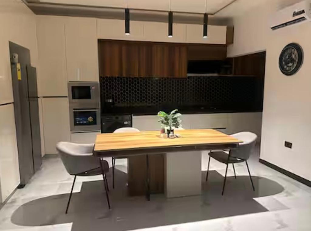 a kitchen with a wooden table and chairs at Rouge Villa in Winneba