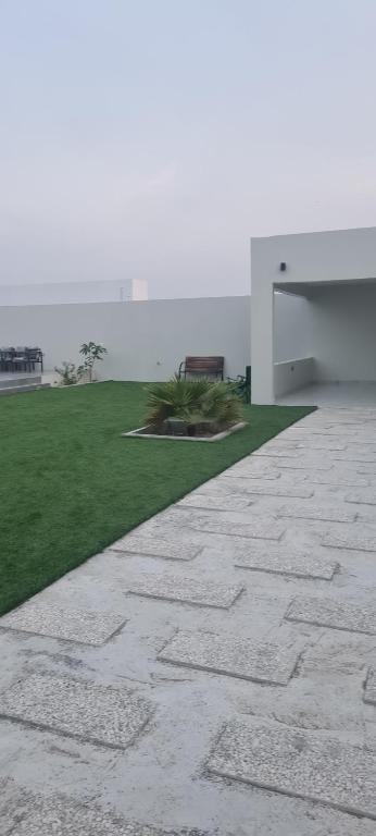 a stone walkway in front of a white building at حكاية سما in Āsam