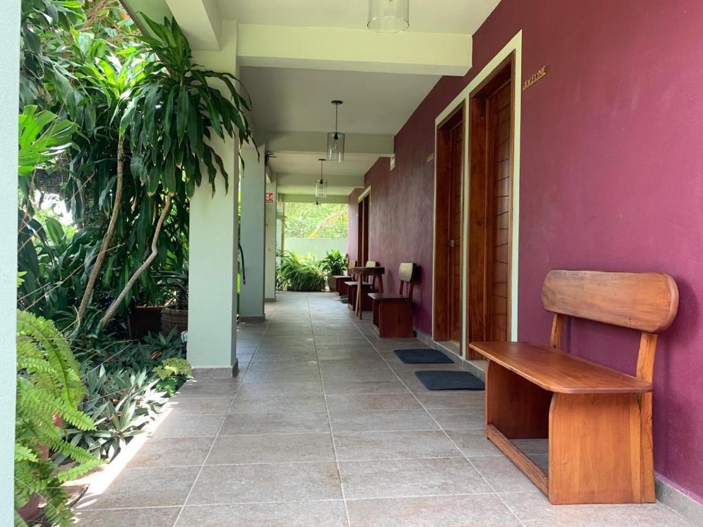 a hallway with a bench and a purple wall at La Morada, una ventana al golfo - Hotel boutique in Monte Gordo