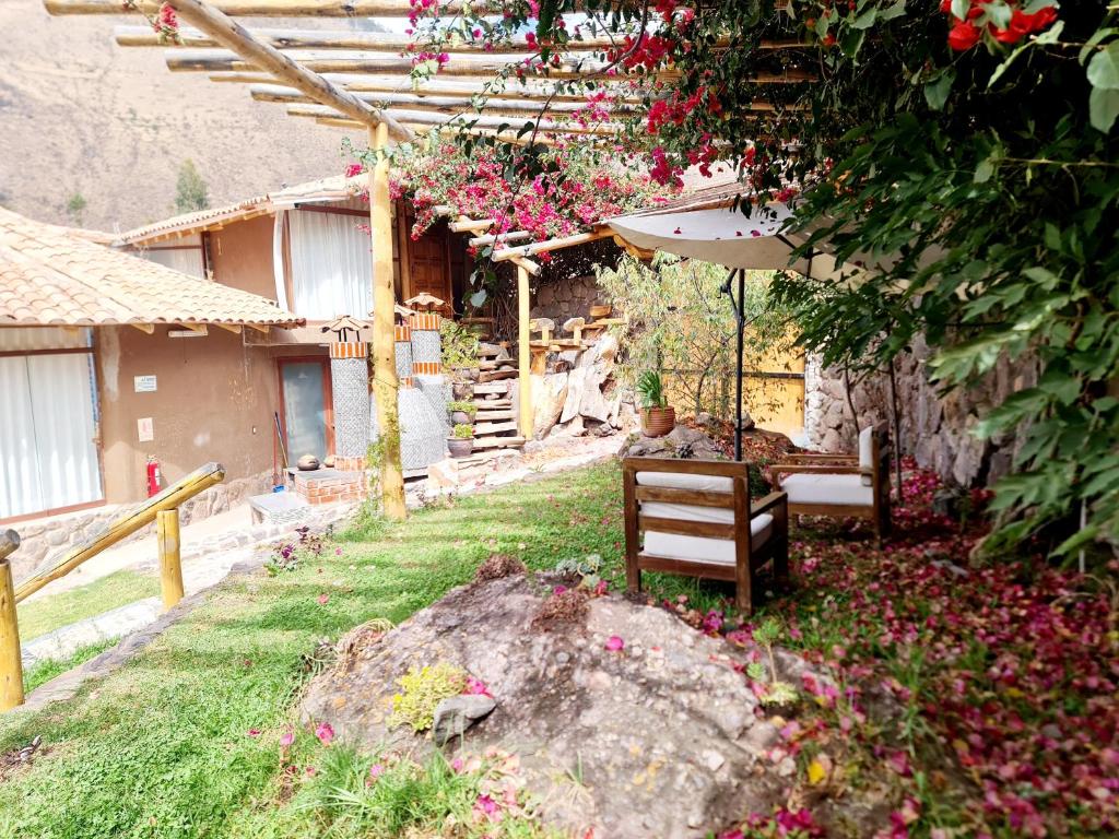 a garden with a bench and an umbrella at Arins House in Cusco