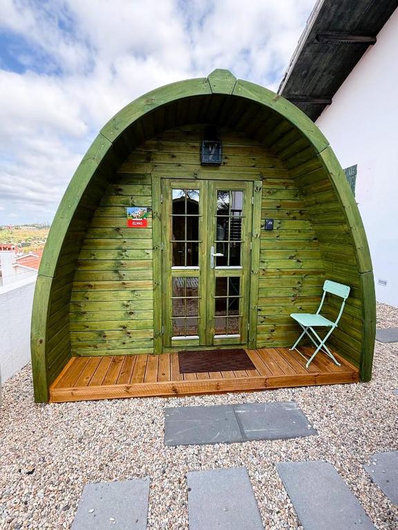 a green building with a chair in front of it at LEIRIA Side Bungalow in Leiria