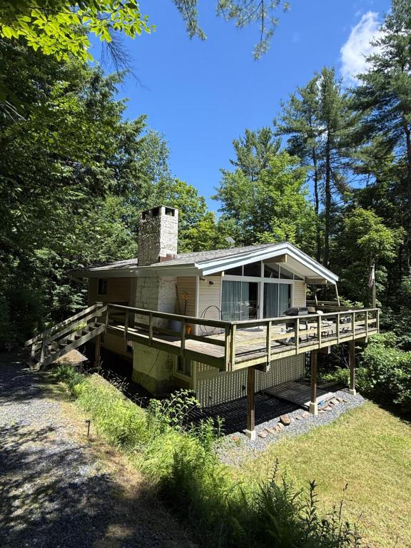 a home with a large deck and a chimney at Cabin on the hill Ascutney in Jenneville