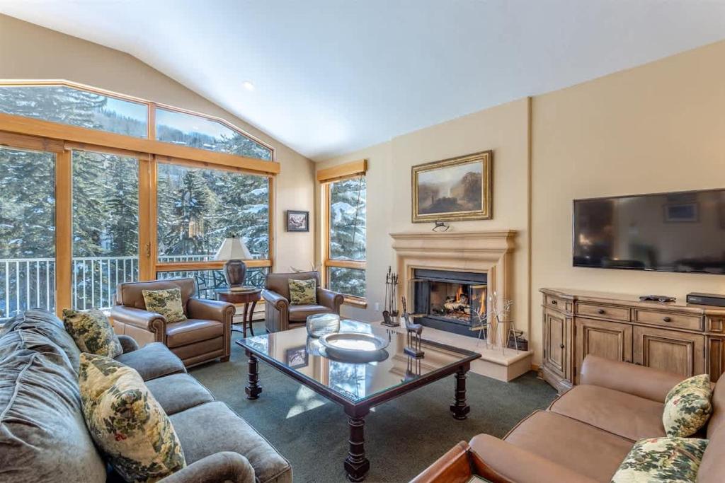 a living room with a couch and a fireplace at Gore Creek Alpine Chalet in Vail