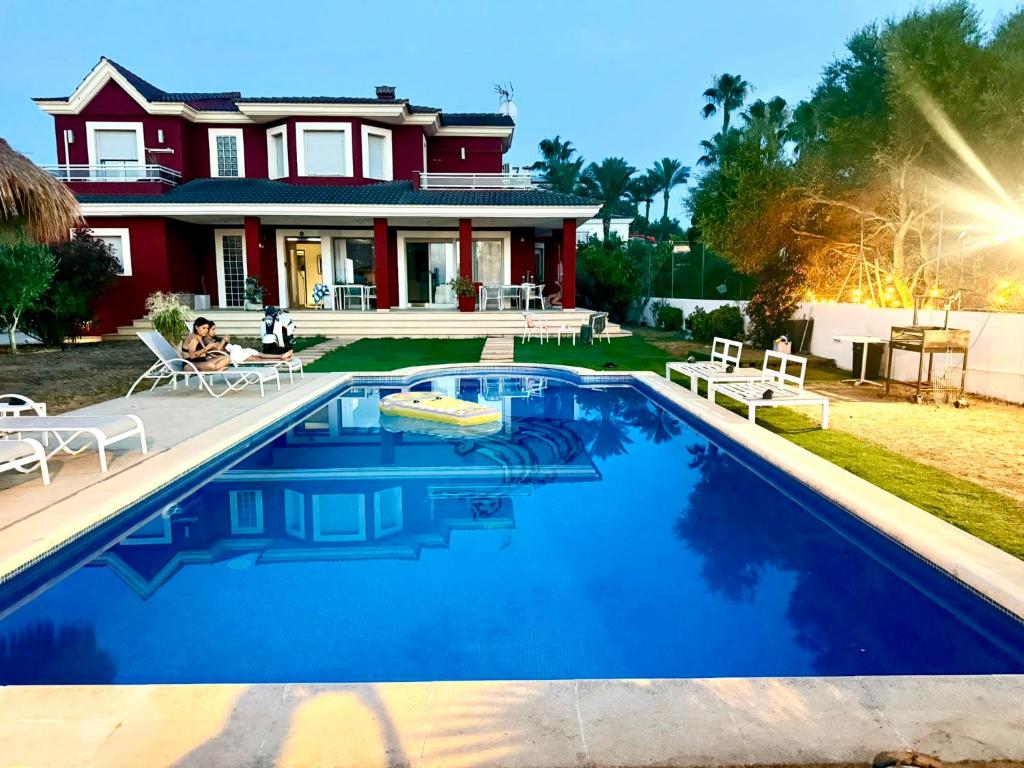 a house with a swimming pool in front of a house at Red House Rooms in Llucmajor