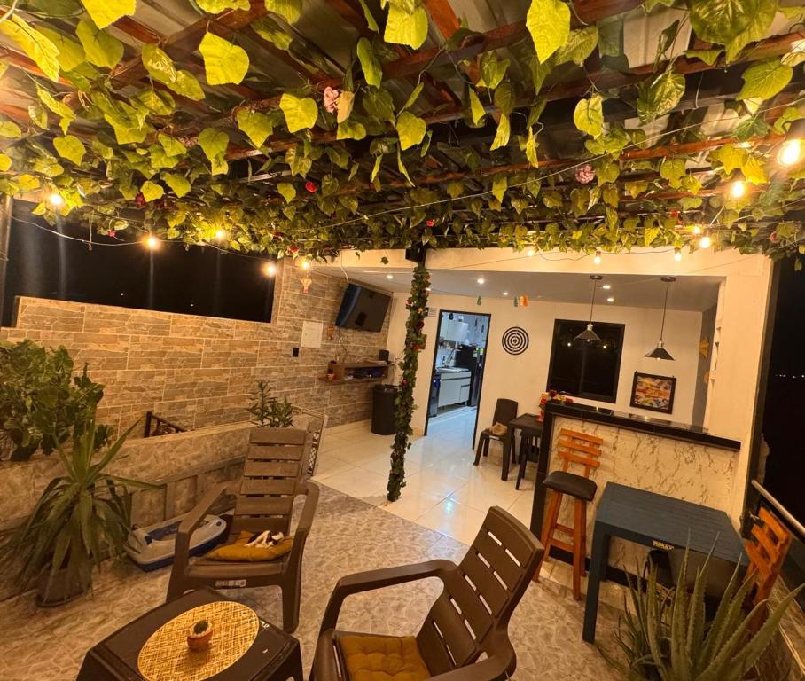 a living room with tables and chairs and a ceiling with plants at Apart Hotel miwi in Los Patios