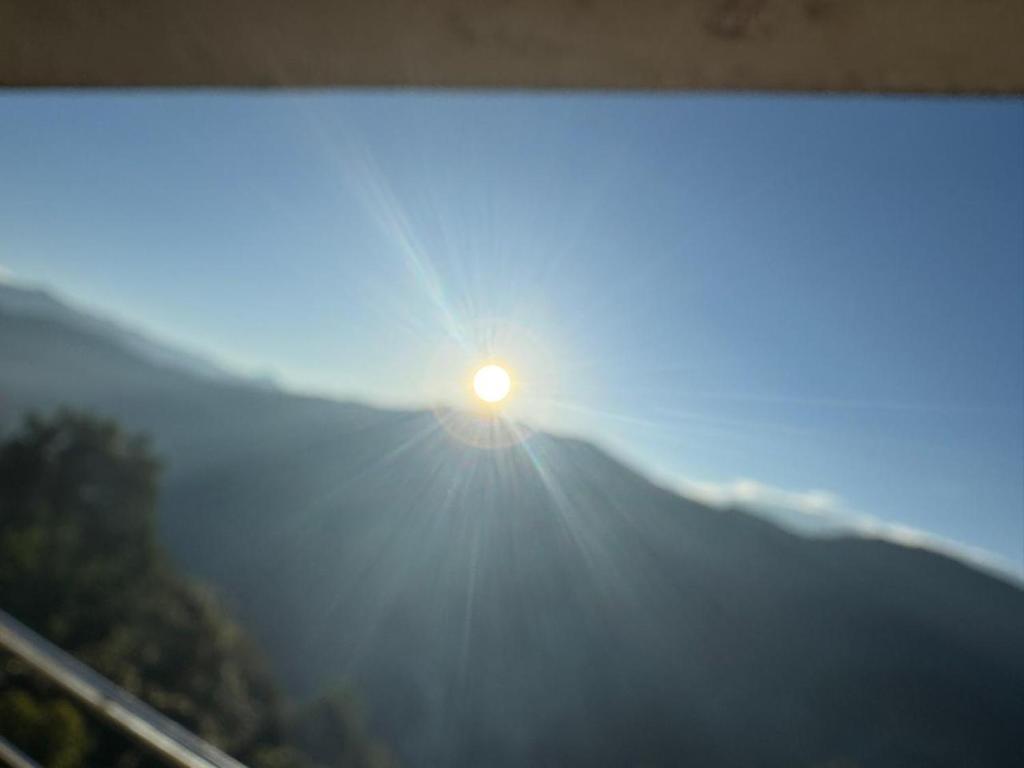 a view of the sun rising over a mountain at Margaret's Himalayan Nest in Kalimpong