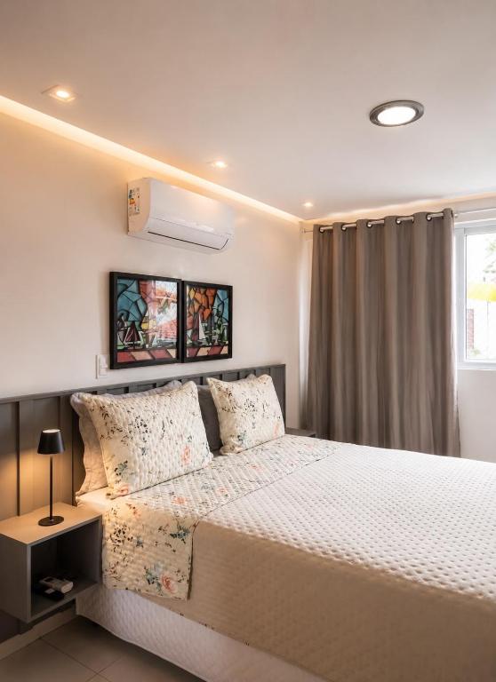 a bedroom with a large bed and a window at APART HOTEL MANAIRA PALACe 2 in João Pessoa