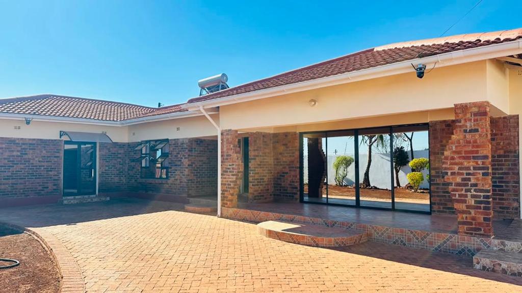 a brick house with a large glass door at The Golden Palace in Bulawayo